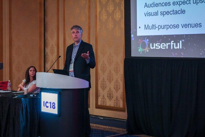 Tim Griffin, CTO of Userful, giving a presentation about AV-over-IP at Infocomm 2018, with Marielle Crisanti of Matrix Video Communications in the background