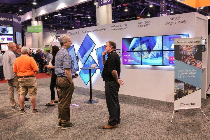 A man talking to a Userful employee in front of a Userful booth at Infocomm 2018