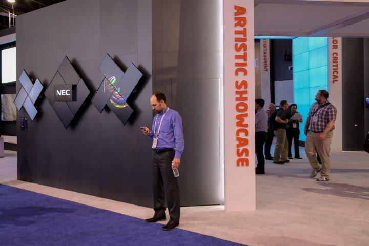 3 NEC video walls powered by Userful's platform for an artisitc showcase at Infocomm 2018 with a man standing in front of it