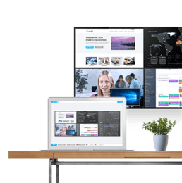 Laptop using Userful manager to display content on the video wall behind it, sitting on desk beside a plant