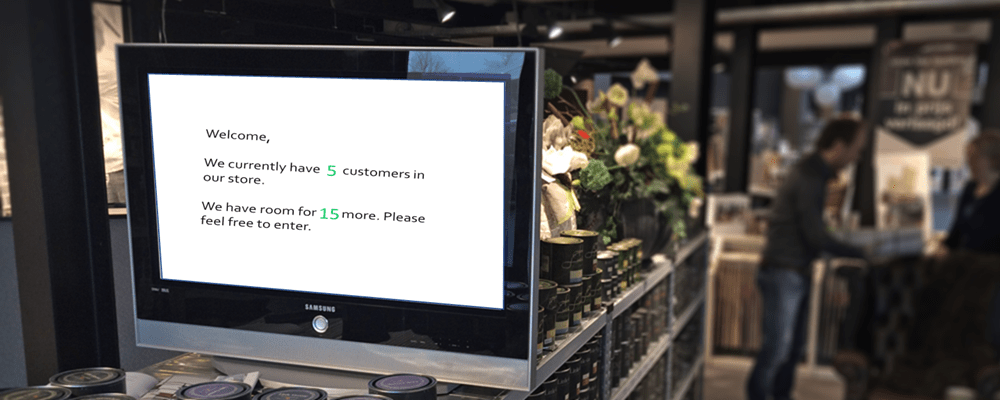 A monitor displaying a live number of customers in store message powered by REST-API, in a store