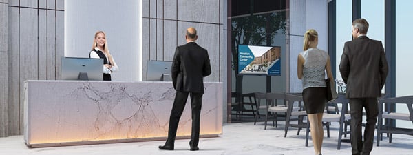 Modern building lobby with tall ceilings, sitting area, receptionist, and 3 workers standing