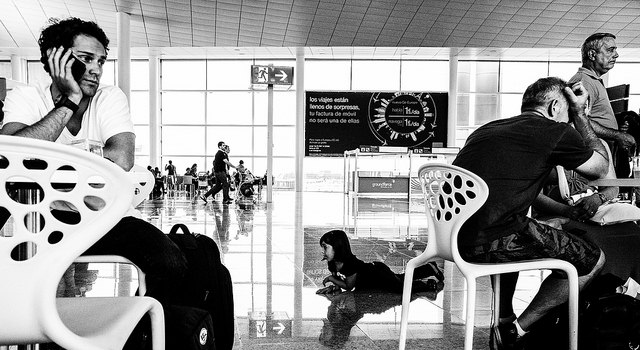 Airport with video wall displaying advertisements, black and white filter