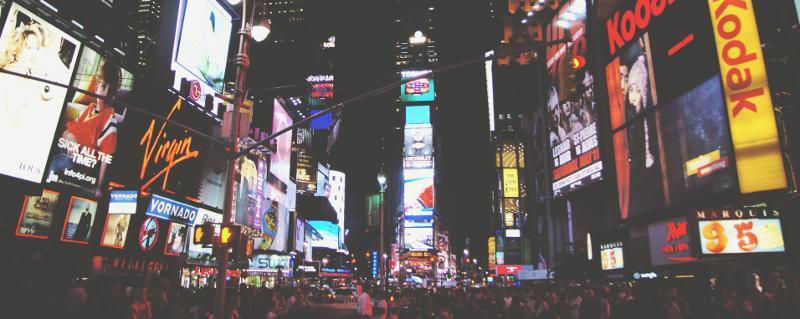 New York City's Times Square filled with video walls and digital signage, and many people at night