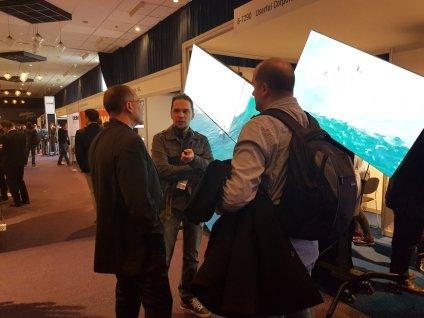 Userful employees and attendes chat at in front of a mosaic video wall at ISE 2018 Amsterdam