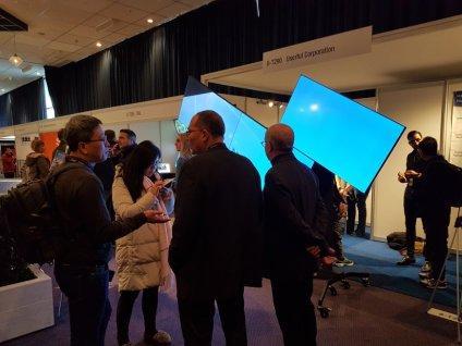 Userful employees and attendes chat at in front of a mosaic video wall at ISE 2018 Amsterdam