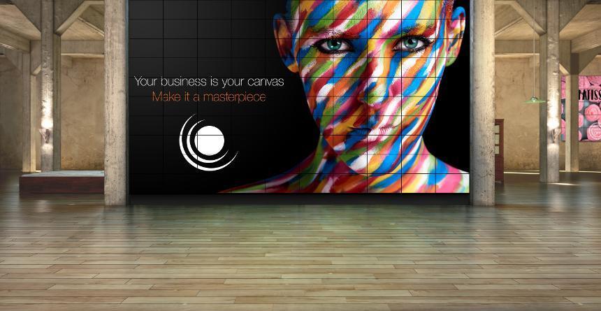 Large video wall with image of a woman with a colorful painted face. Text reads: Your business is your canvas. Make it a masterpiece.