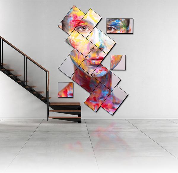 A modern staircase and an artistic mosaic video wall displaying an art piece of a painted face