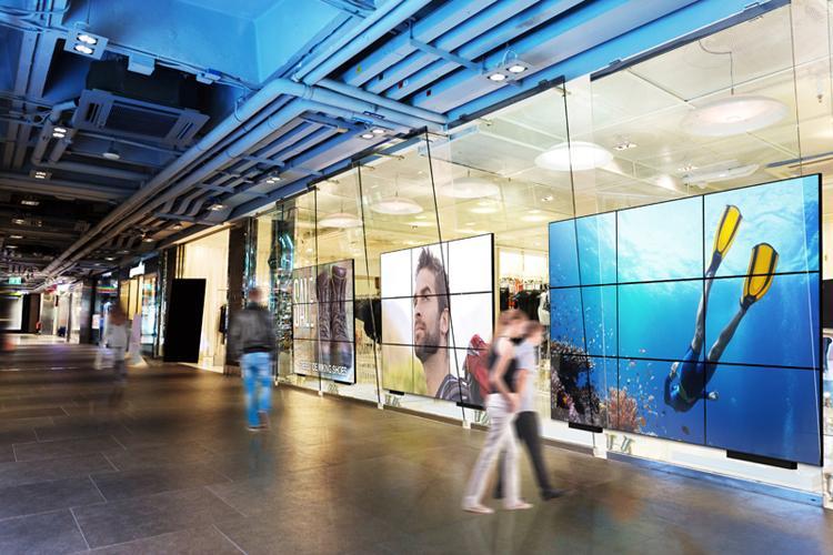 Multiple large Userful video walls in a mall hallway, displaying advertisements and art